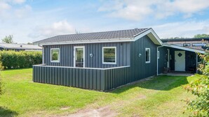 A single-story mobile home with a flat roof, a front porch, and a small attached garage. - 4 Star Holiday Home in Haderslev (Haderslev)