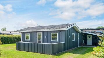 A single-story mobile home with a flat roof, a front porch, and a small attached garage.