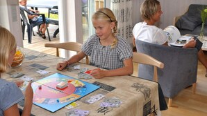 Un grupo de personas jugando un juego de mesa con un tablero de Monopoly.