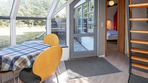 A modern interior with a checkered table, two chairs, a bed, and a wooden shelf. - Lovely Holiday Home in Lemvig with Hot Tub (Lemvig)