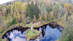 A natural landscape with a pond, trees, and a small cabin. - 6 Person Holiday Home in Ryssby (Ryssby)