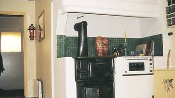 A kitchen with a stove, microwave, and a small refrigerator.