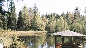A wooden gazebo by a calm lake surrounded by dense forest. - 6 Person Holiday Home in Ryssby (Ryssby)