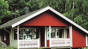 A red wooden cabin with a white porch and a chimney. - 6 Person Holiday Home in Arboga-by Traum (Arboga)