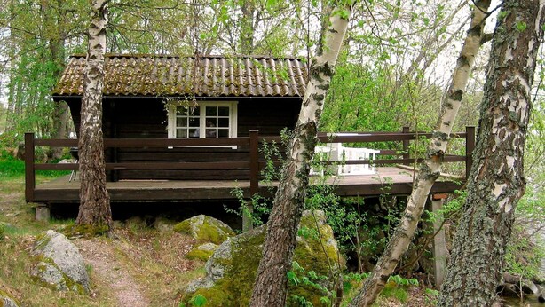 A rustic cabin with a tiled roof, surrounded by trees and rocks. - 6 Person Holiday Home in Arboga-by Traum (Arboga)