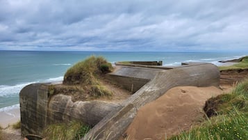 A coastal landscape with a concrete structure, possibly a fortification, overlooking the sea.