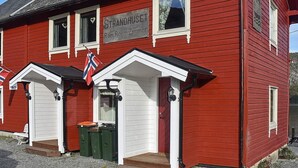 A red building with a sign reading 'Strandhuset Rom.Room.Zimmer.' - Holiday Home in MÃ¥ndalen (Rauma)