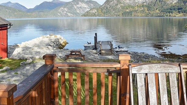 Eine Holterrasse mit Blick auf einen See und Berge.