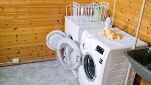 A laundry room with two washing machines, a drying rack, and a sink. - 5 Person Holiday Home in Engavagen (Meloy)