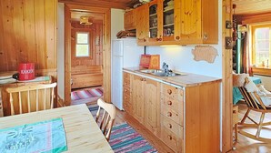 L’intérieur d’une cabane en bois comprend un coin cuisine, une table à manger et un espace salon confortable.