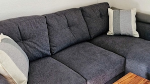 A grey sectional sofa with a wooden coffee table in front. - 5 Person Holiday Home in Hunnebostrand (Hunnebostrand)