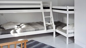 A bunk bed room with a wooden ladder, a small table, and a striped rug. - 5 Person Holiday Home in Hunnebostrand (Hunnebostrand)