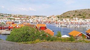 A coastal town with red-roofed buildings, a marina with boats, and a hilly backdrop. - 5 Person Holiday Home in Hunnebostrand (Hunnebostrand)