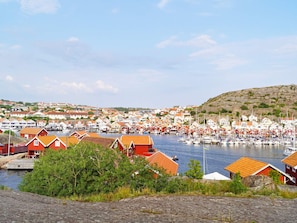A coastal town with red-roofed buildings, a marina with boats, and a hilly backdrop. - 5 Person Holiday Home in Hunnebostrand (Hunnebostrand)