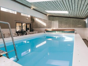 An indoor swimming pool with a wooden ceiling, a bench, and a table with chairs. - 5 Star Holiday Home in Hals (Asaa)