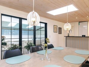 A modern conference room with a large table, chairs, and pendant lighting. - 5 Star Holiday Home in Hals (Asaa)