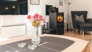 A modern living room with a fireplace, a flat-screen TV, and a comfortable seating area. - 5 Star Holiday Home in Hals (Asaa)