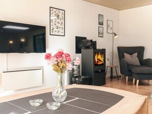 Una sala de estar moderna con chimenea, televisor de pantalla plana y un espacio de descanso confortable.