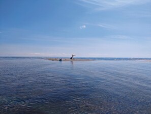 A beach with clear water, a small boat, and a beach umbrella. - 5 Star Holiday Home in Hals (Asaa)