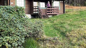 A wooden cabin with a porch and a staircase leading up to it. - 5 Person Holiday Home in Brekke-by Traum (Gulen)