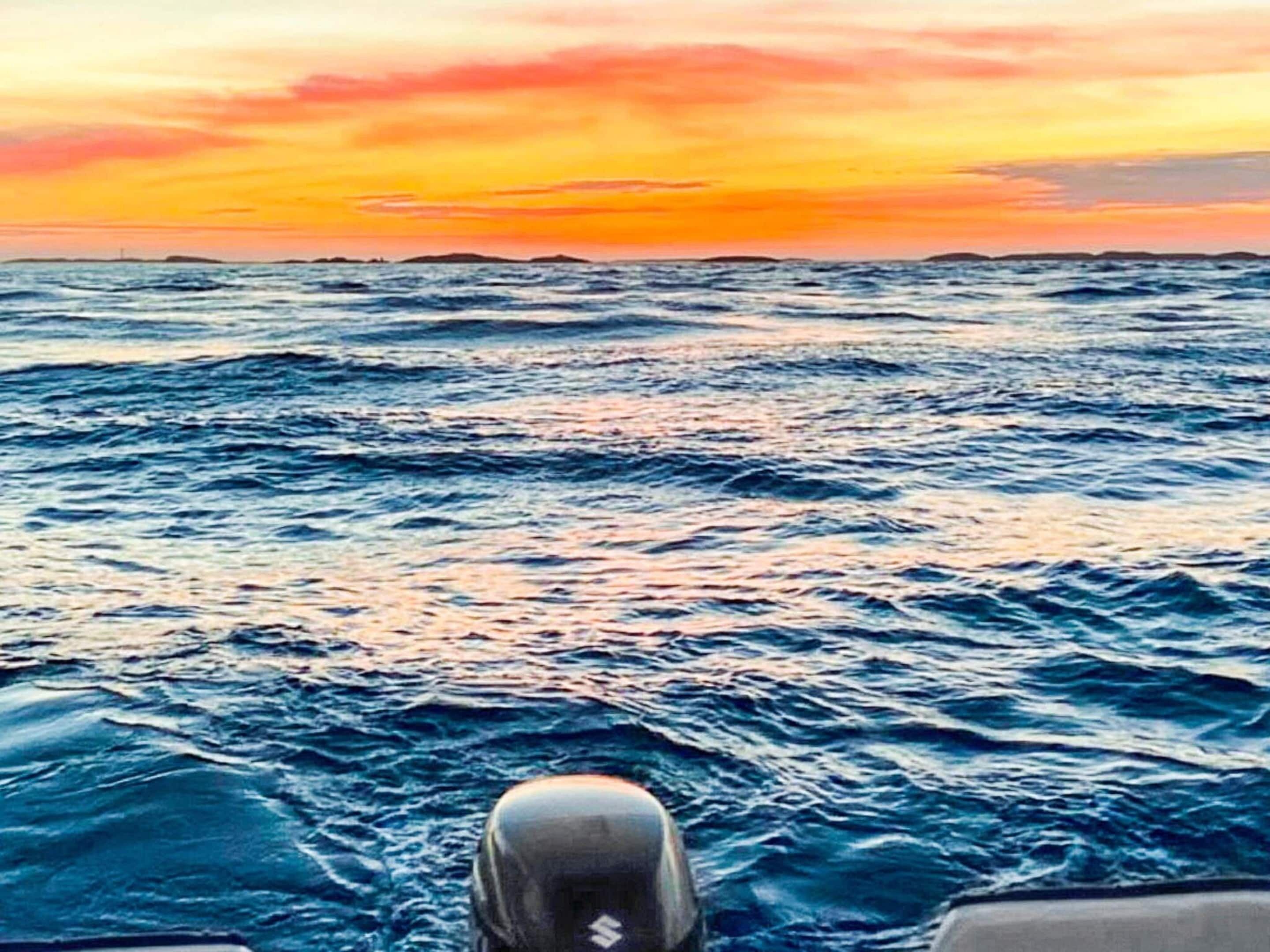 A view from a boat at sea during sunset.