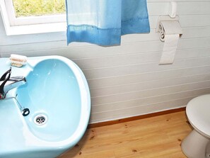 A bathroom with a blue sink, a toilet, and a window with a view of greenery. - 6 Person Holiday Home in Rubbestadneset (Bomlo)