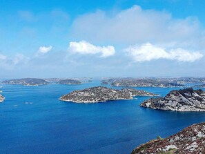 A coastal landscape with rocky outcrops and calm blue waters. - 6 Person Holiday Home in Rubbestadneset (Bomlo)