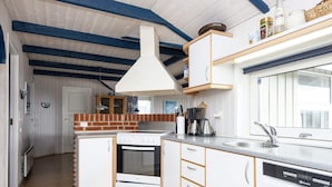 A modern kitchen with white cabinets, a built-in oven, a dishwasher, and a hanging light fixture. - 9 Person Holiday Home in Borkop-by Traum (Borkop)