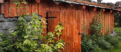 A rustic wooden building with a metal roof and a chimney.