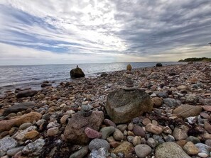 A rocky beach with a calm sea and overcast sky. - 4 Star Holiday Home in Aabenraa (Aabenraa)