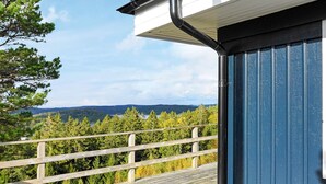 A wooden deck with a view of a forest and mountains. - Holiday Home in HenÃ¥n (Henån)