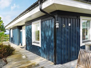 A blue building with a white window trim, a number 21 sign, and a wooden bench. - Holiday Home in HenÃ¥n (Henån)