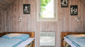 A room with two wooden beds, a window, and wall-mounted artwork. - Simplistic Holiday Home in Blokhus With Sea Nearby (Aabenraa)
