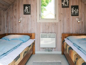 A room with two wooden beds, a window, and wall-mounted artwork. - Simplistic Holiday Home in Blokhus With Sea Nearby (Aabenraa)