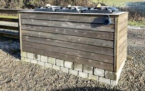 Une structure en bois avec une base en briques, qui pourrait être un abri de jardin ou un local technique.