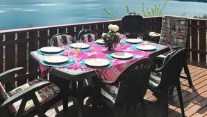 Een eettafel buiten, met uitzicht op een meer en bergen.