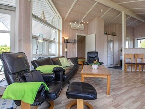Un salon confortable avec un canapé, des fauteuils, une table basse et un coin repas.