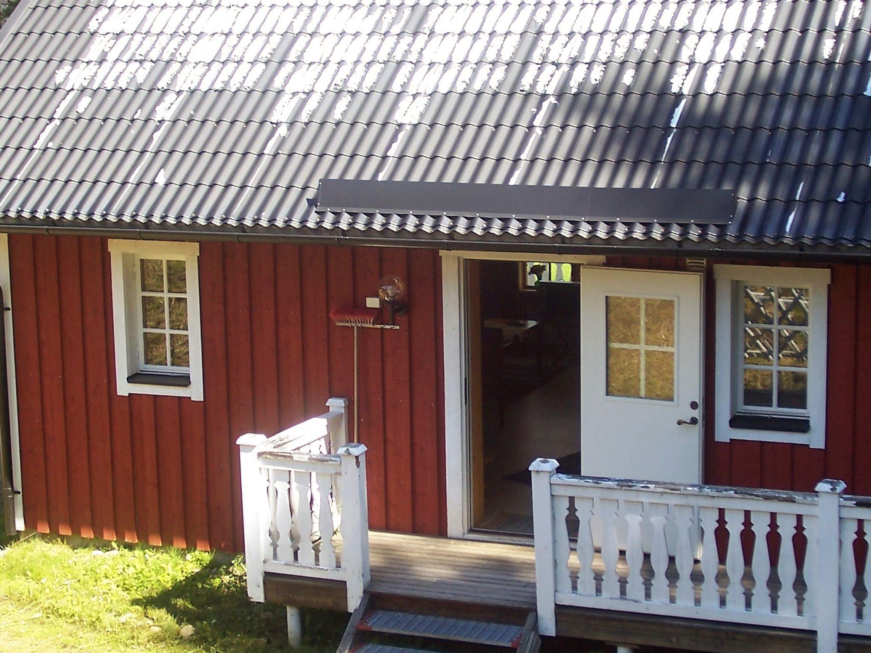 A red building with a white porch and a door.