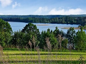 A natural landscape with a lake, trees, and a distant forested hill. - 4 Person Holiday Home in Bello (Hjältevad)