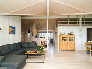 A spacious living area with a sofa, coffee table, and wooden cabinets.