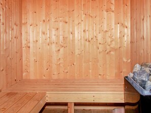 A sauna room with wooden walls and a bench. - Holiday Home in Gelting (Gelting)