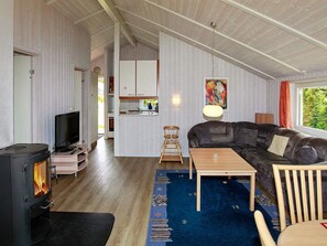 A cozy living room with a fireplace, a sofa, a TV, and a dining area.