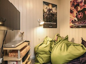 A room with a bed, a poster on the wall, a lamp, and a shelf with items. - 4 Star Holiday Home in Roslev (Roslev)