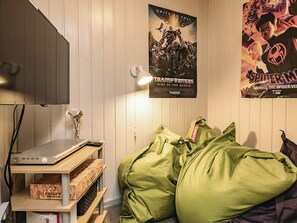 A room with a bed, a poster on the wall, a lamp, and a shelf with items.