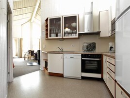 A compact kitchen with a dishwasher, oven, and a coffee maker.