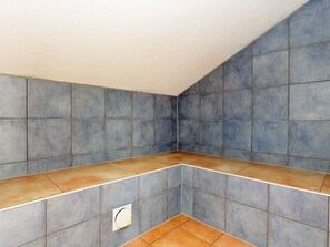 A room with blue tiled walls and a brown-tiled floor. - Holiday Home in Otterndorf (Otterndorf)