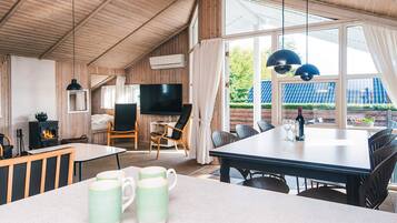 A cozy room with a fireplace, a TV, and a dining area with a table and chairs.