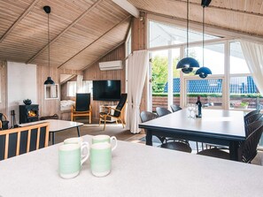 A cozy room with a fireplace, a TV, and a dining area with a table and chairs.