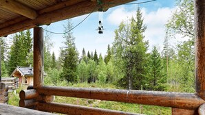 Une cabane en bois avec une table de pique-nique et un luminaire suspendu.