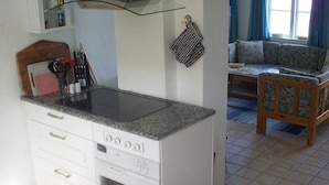 A compact kitchen with a built-in stove, oven, and a small countertop. - 6 Person Holiday Home in Aabenraa (Aabenraa)